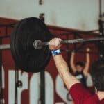 man carrying barbell at the gym