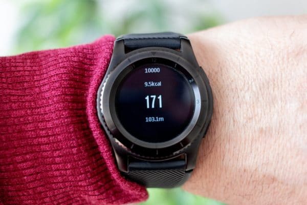 person wearing round black smartwatch